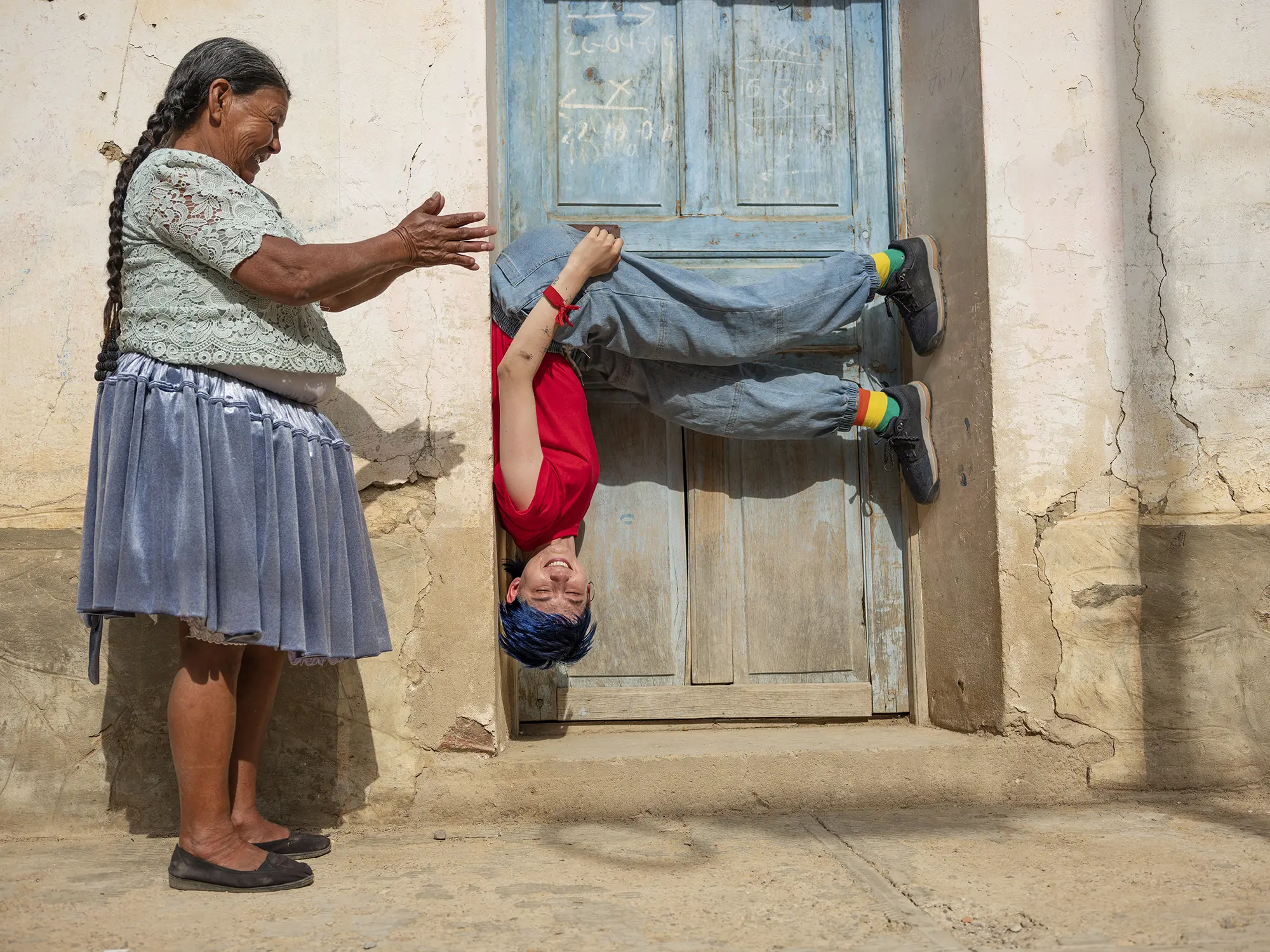 Tam hanging upside down in a door way