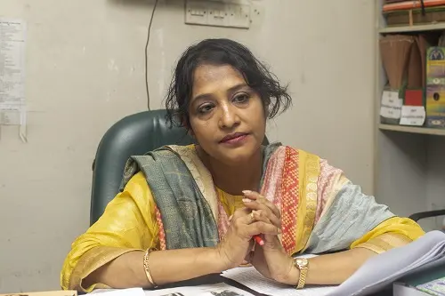 A woman sits behind her desk