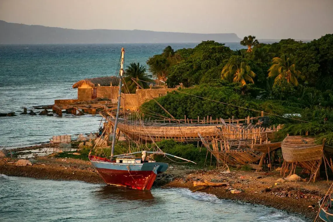 A sail boat on the beach with construction