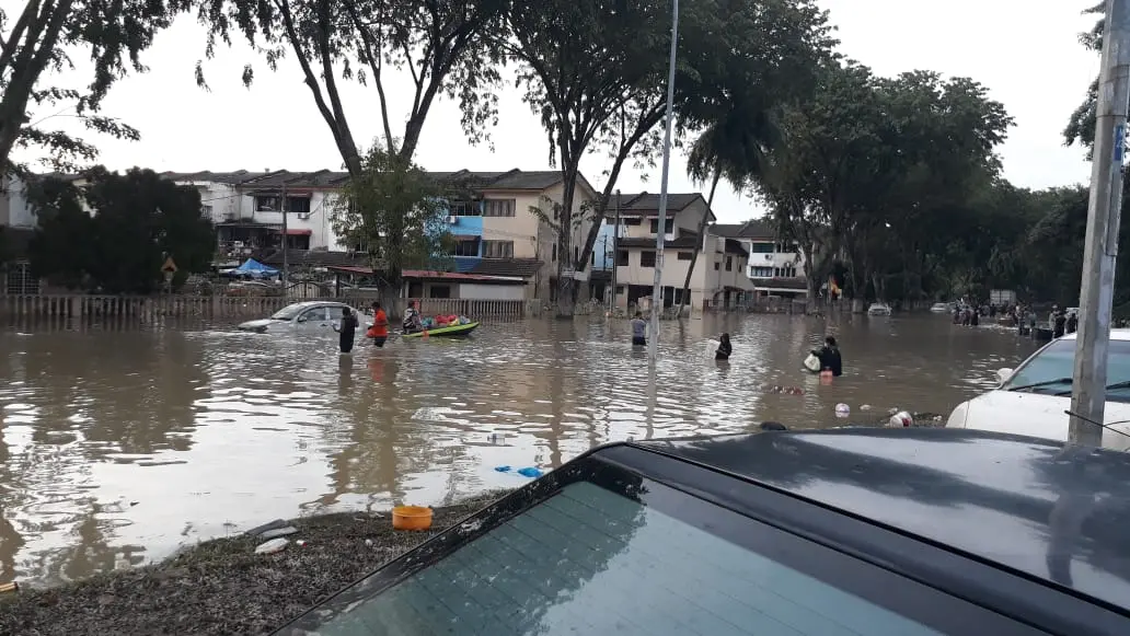 flood survivors wading through water