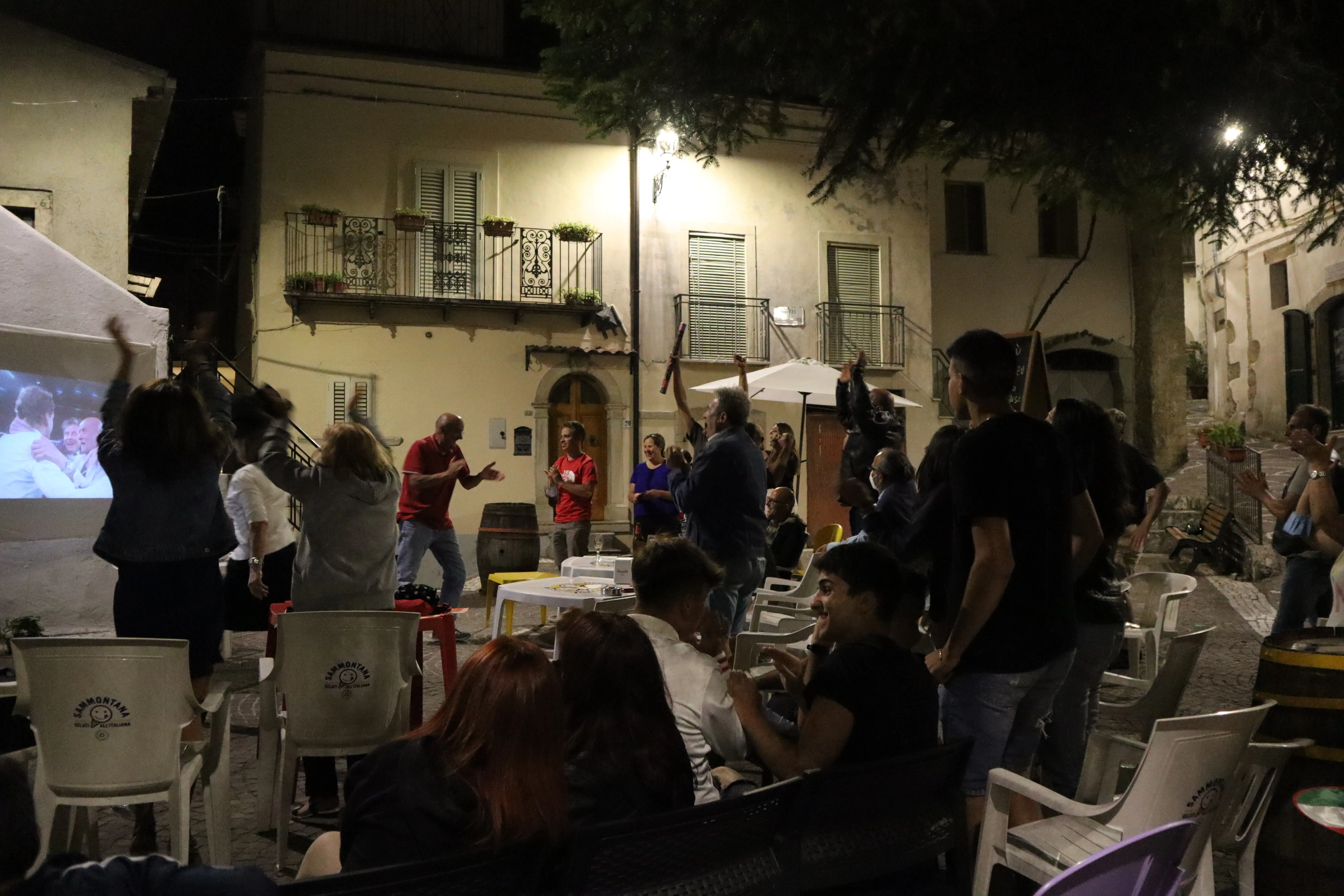People in town celebrate a soccer match win, people are jumping