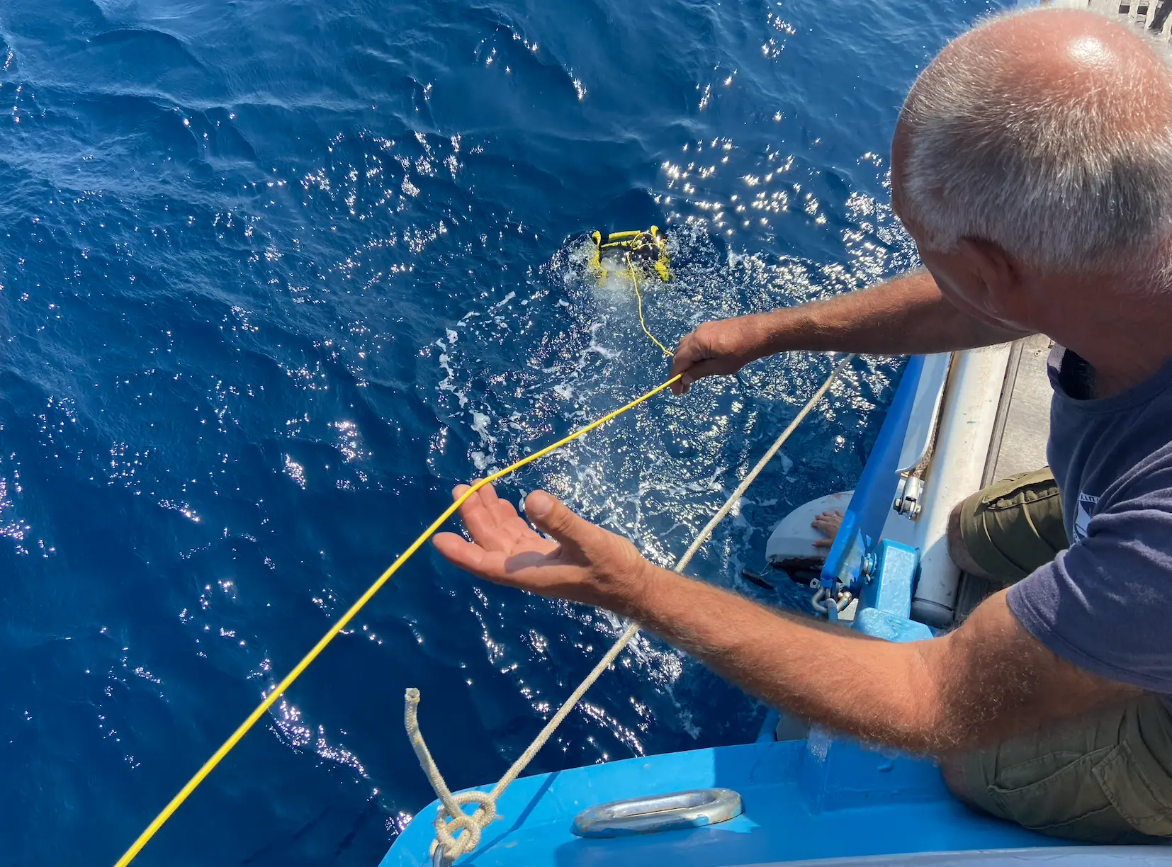 A fisherman in a country fishing boat full of fish at huge fishing