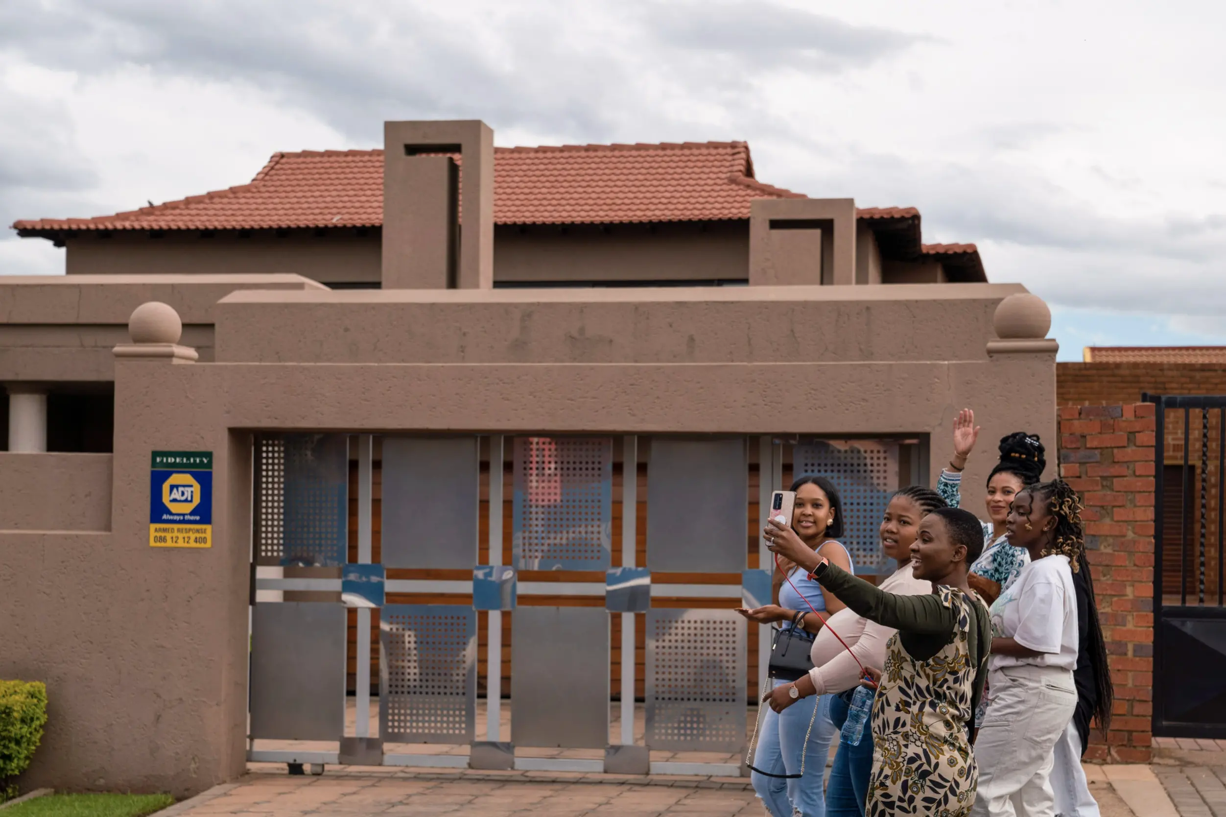 Young women post for a selfie outside a building