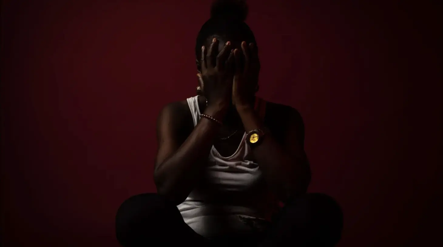 woman posing with hands over face in the shadows