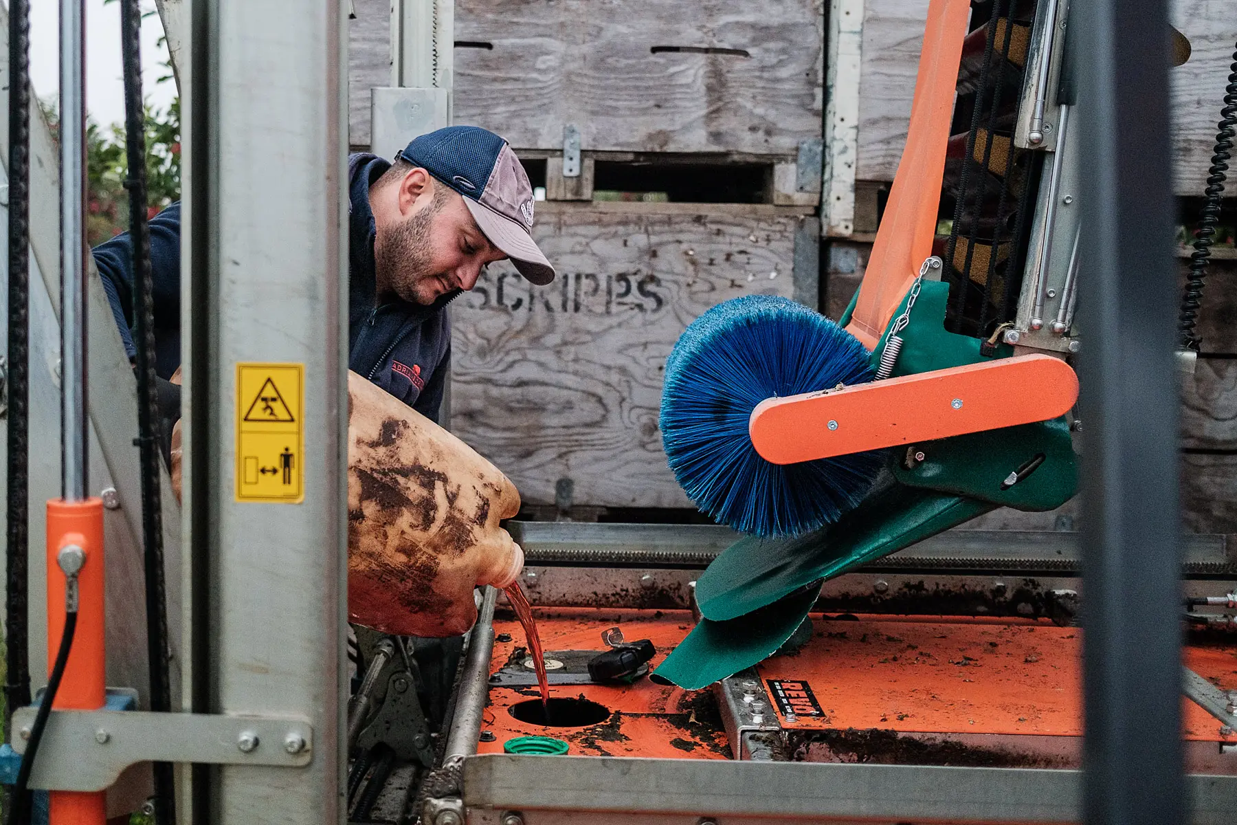 Man pours liquid diesel into an apple picking machine