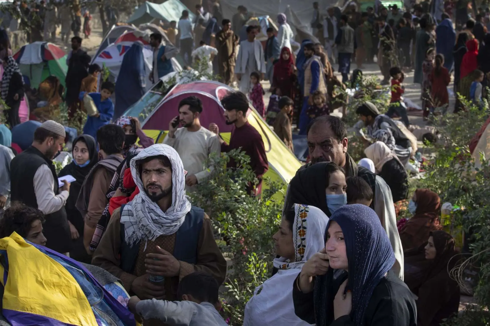 Afghans stand in a refugee gathering spot 