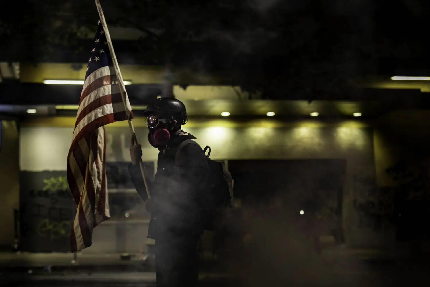 A lone protester holds an American flag.