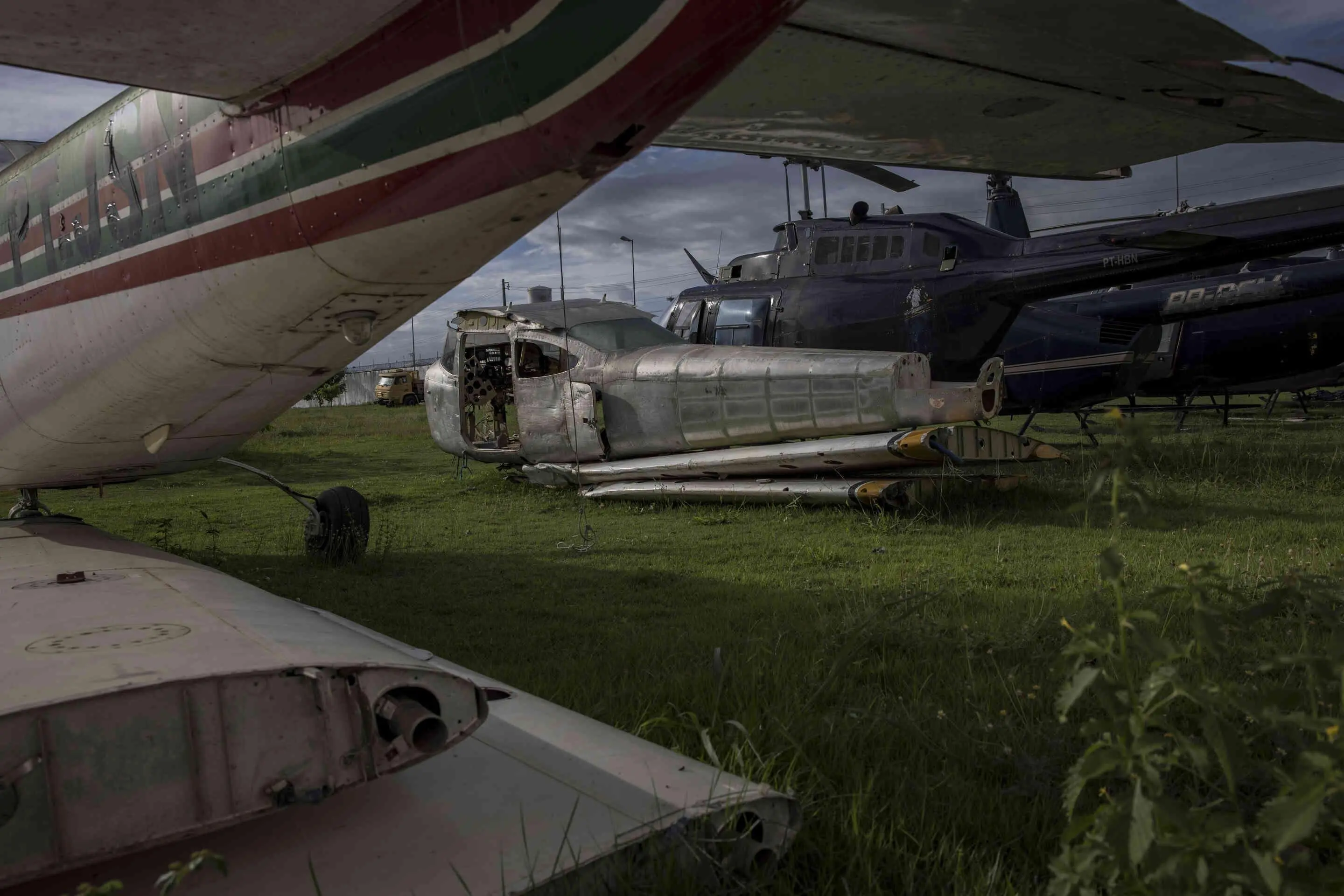 A line of planes stand in a row on the grass.