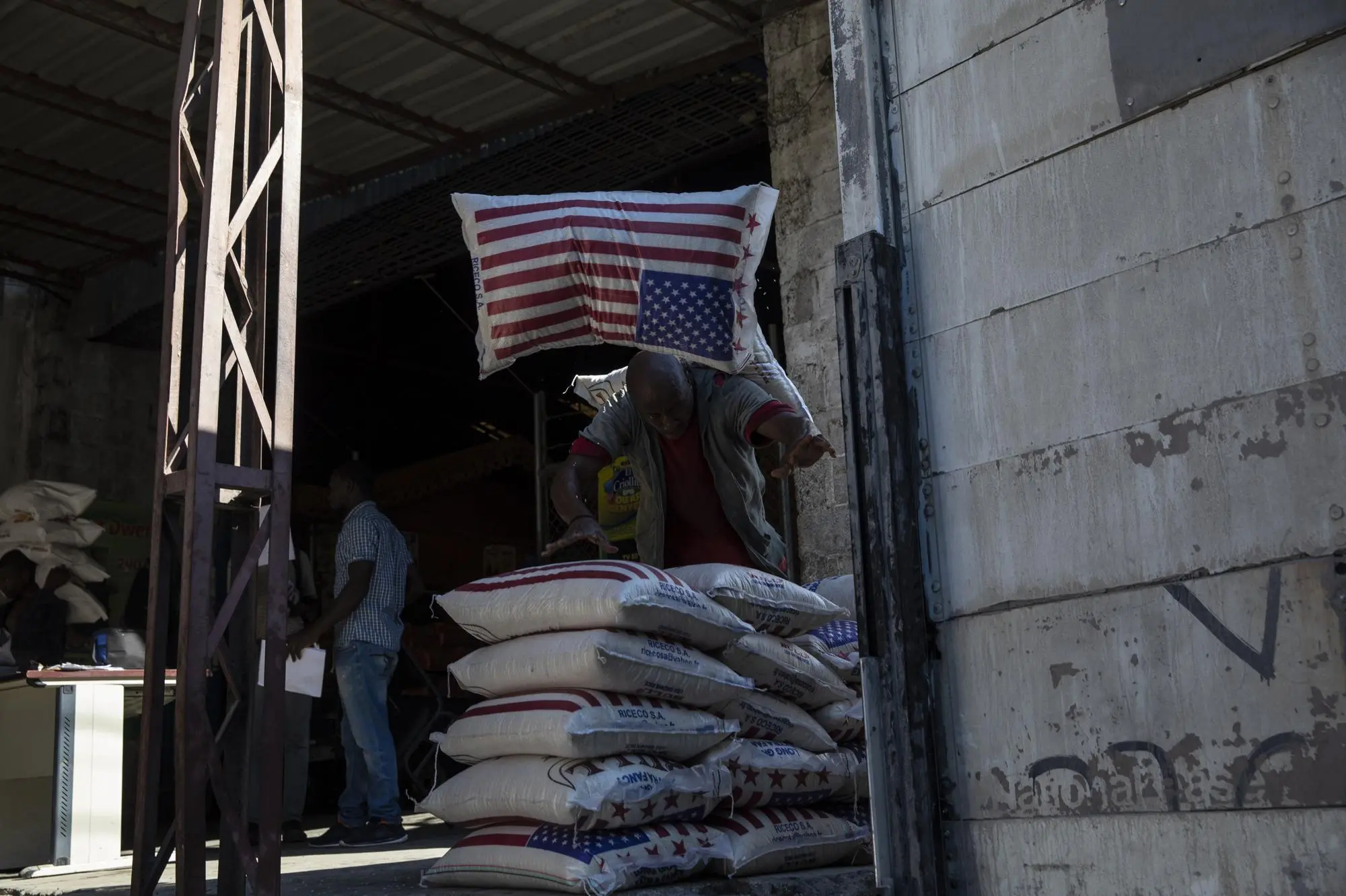 An employee carries imported rice