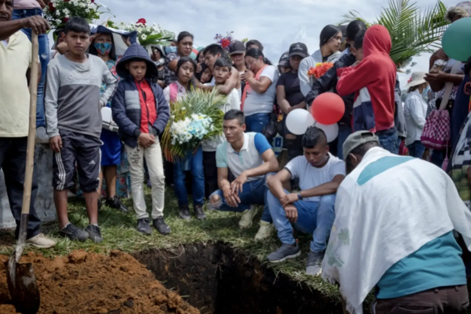 Relatives look down at burial