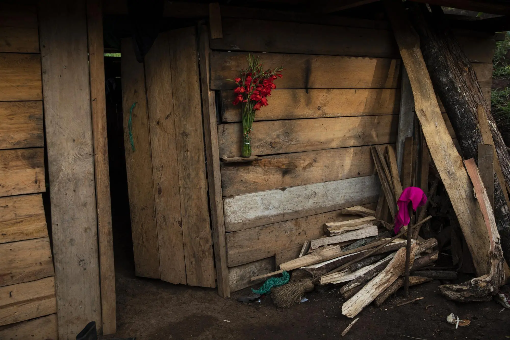 Bouquet in front of doorway of home next to pile of wood