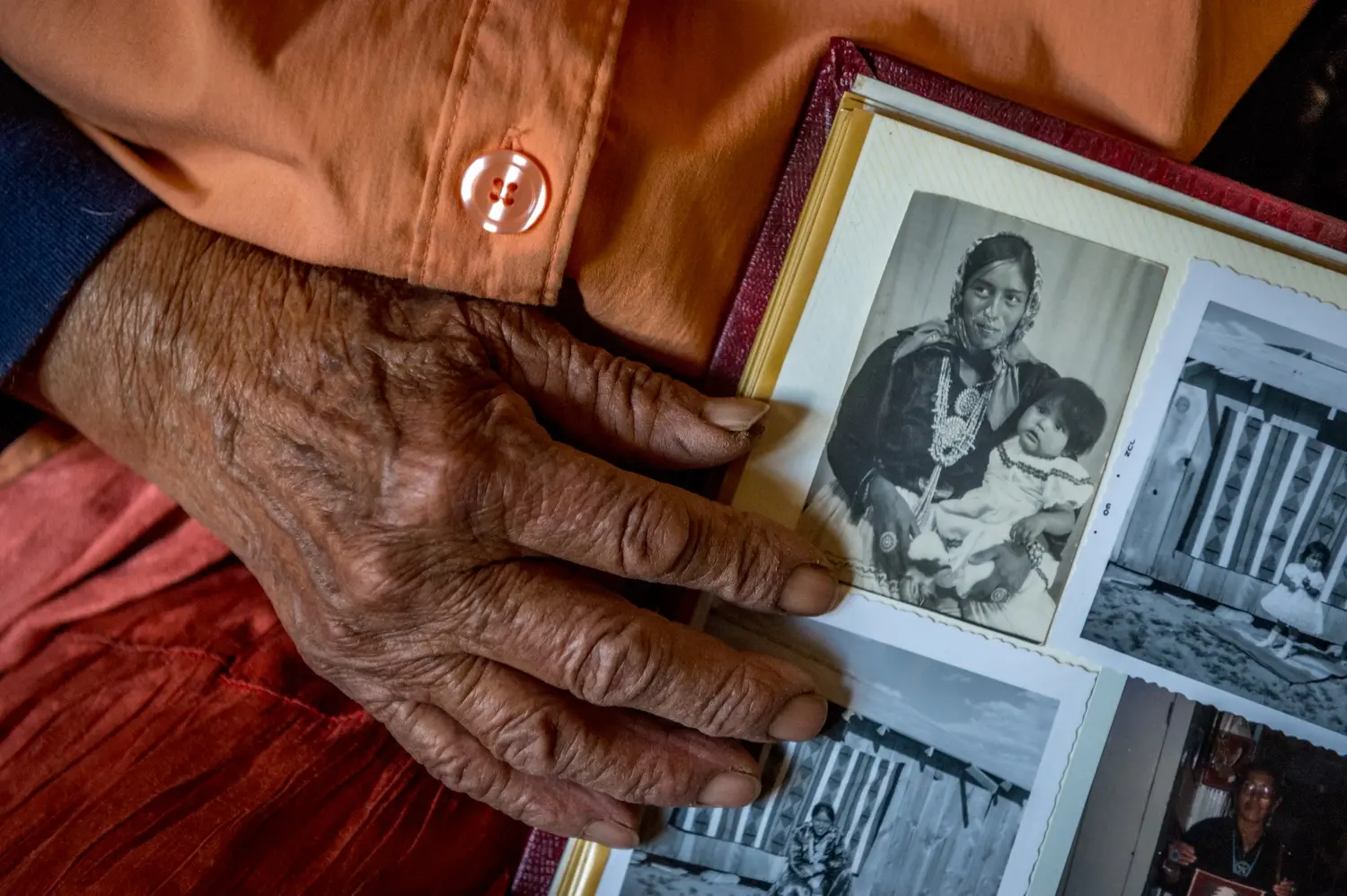 Helen Nez, who began working for the mining companies as a child, looks at pictures of herself as a young mother. Image by Mary F. Calvert. United States.