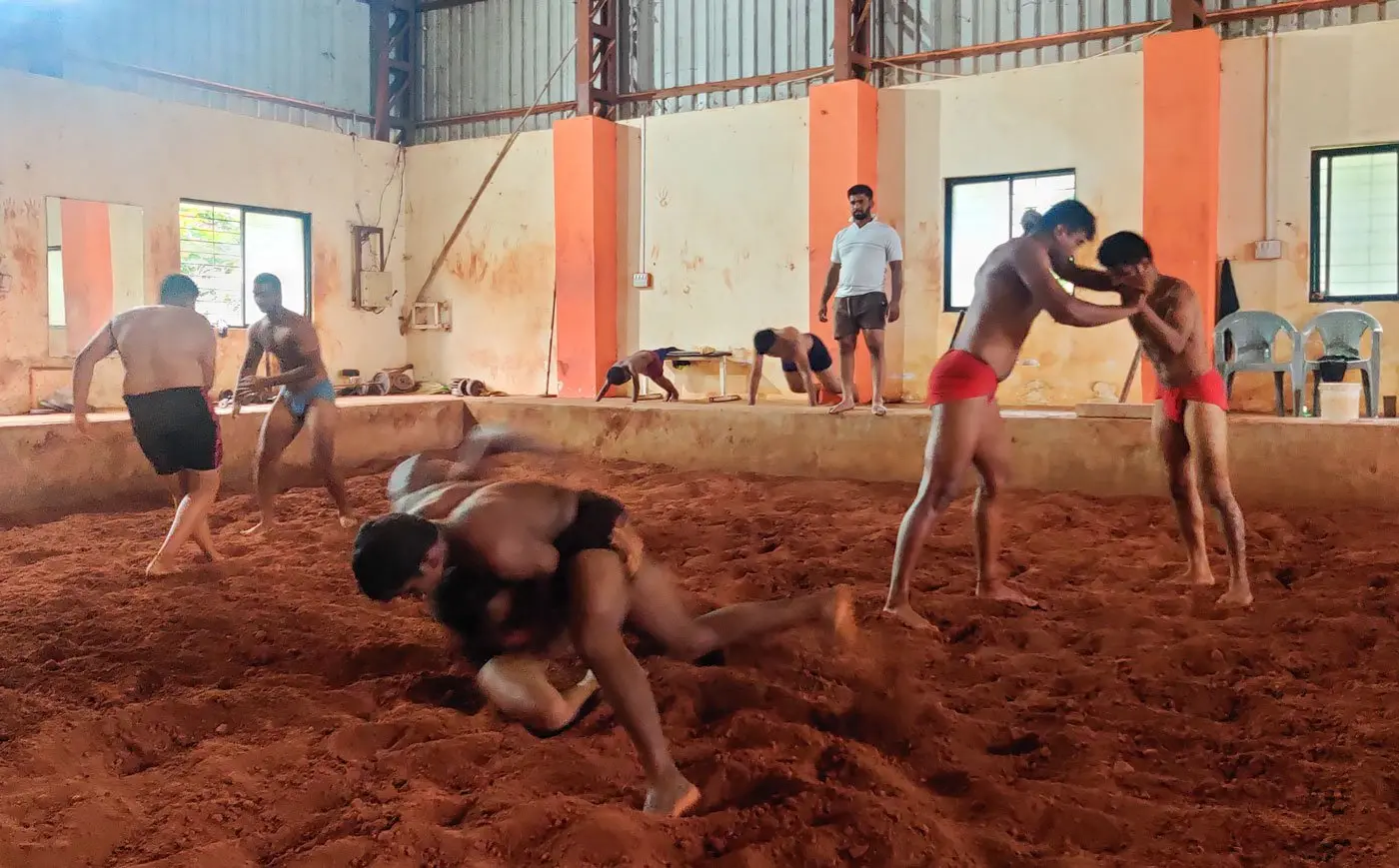 Groups of boys wrestle while coach watches