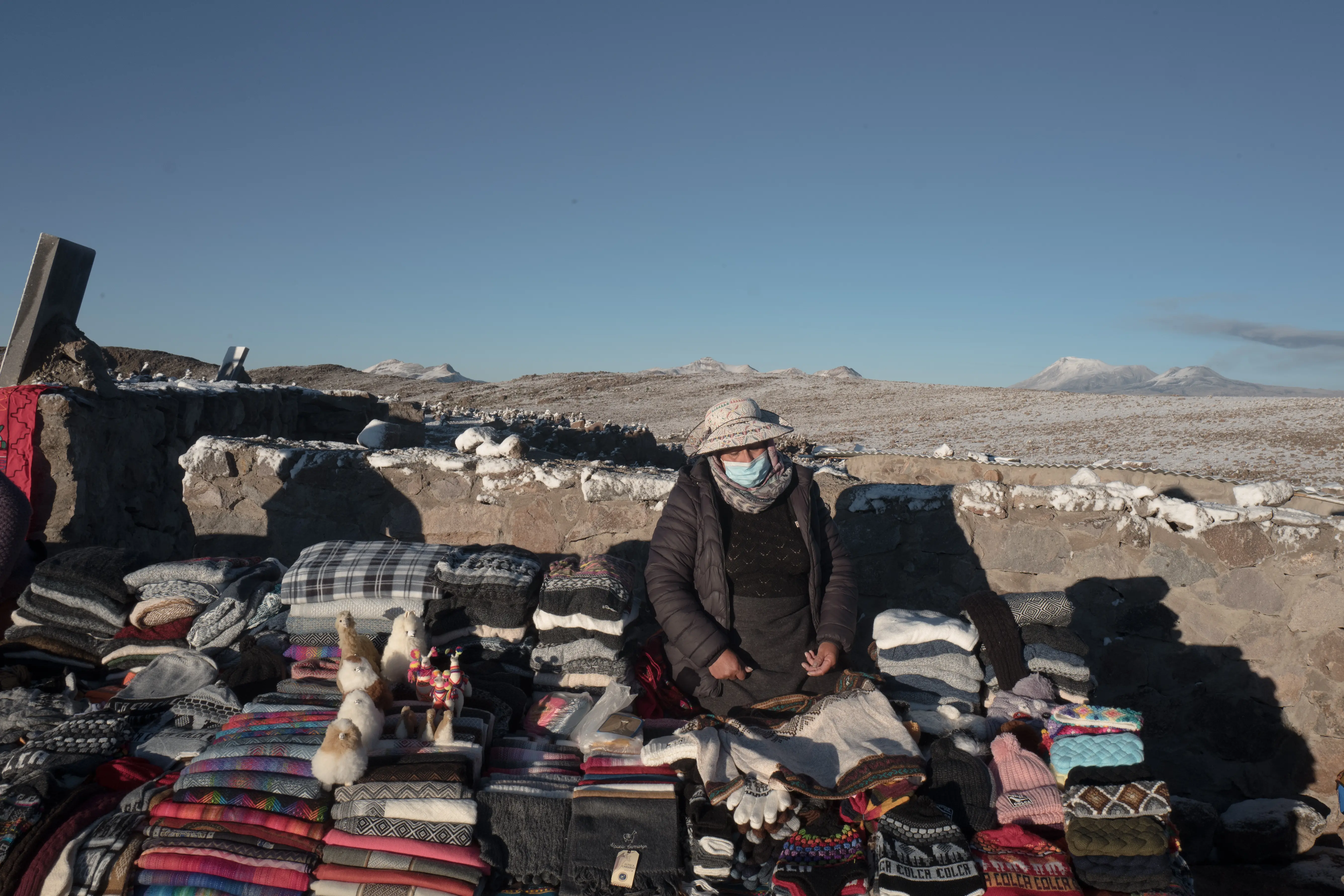 Masked woman sells crafts in Peru