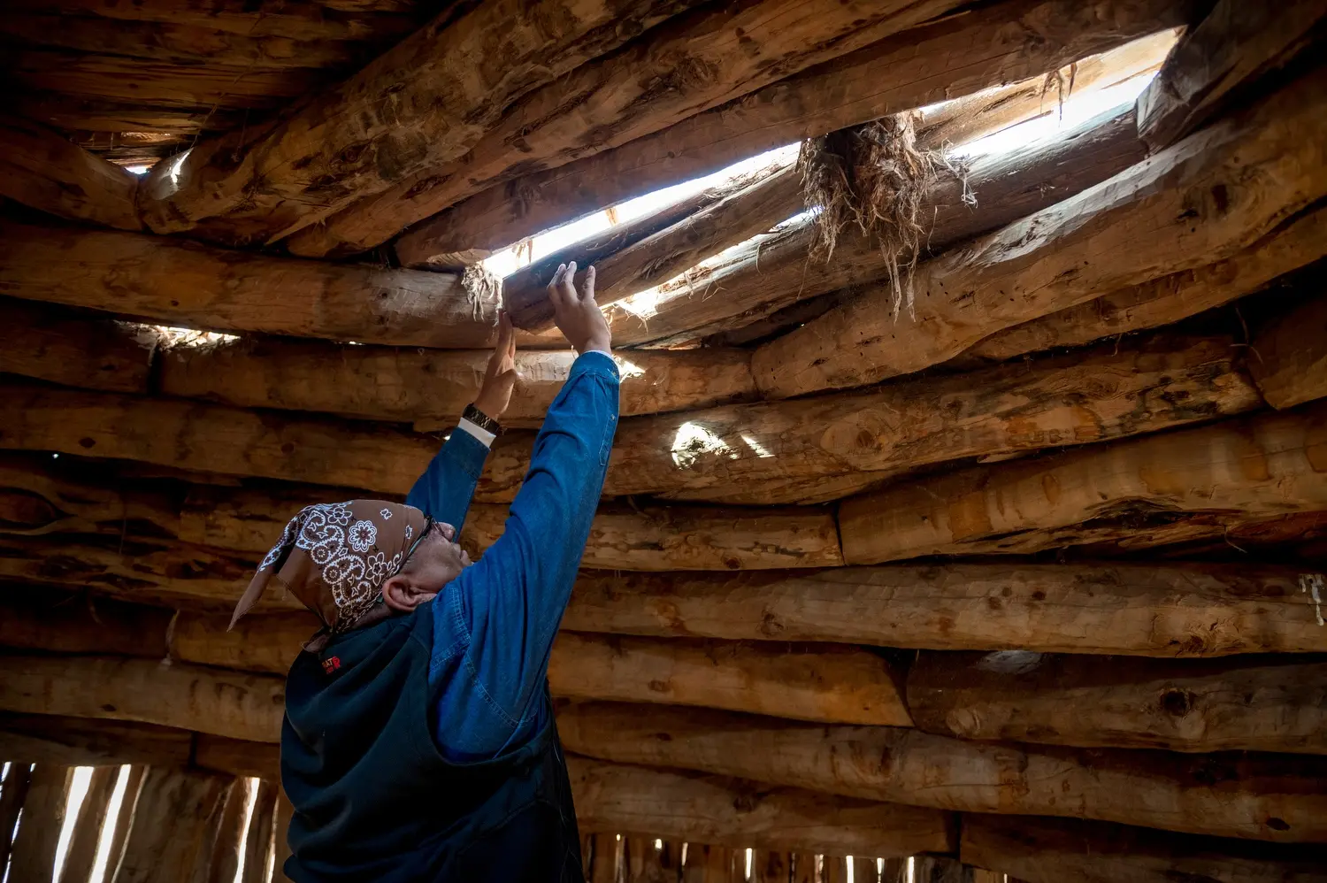 Dariel Yazzie inspecting a structure. Image by Mary F. Calvert. United States, 2020.