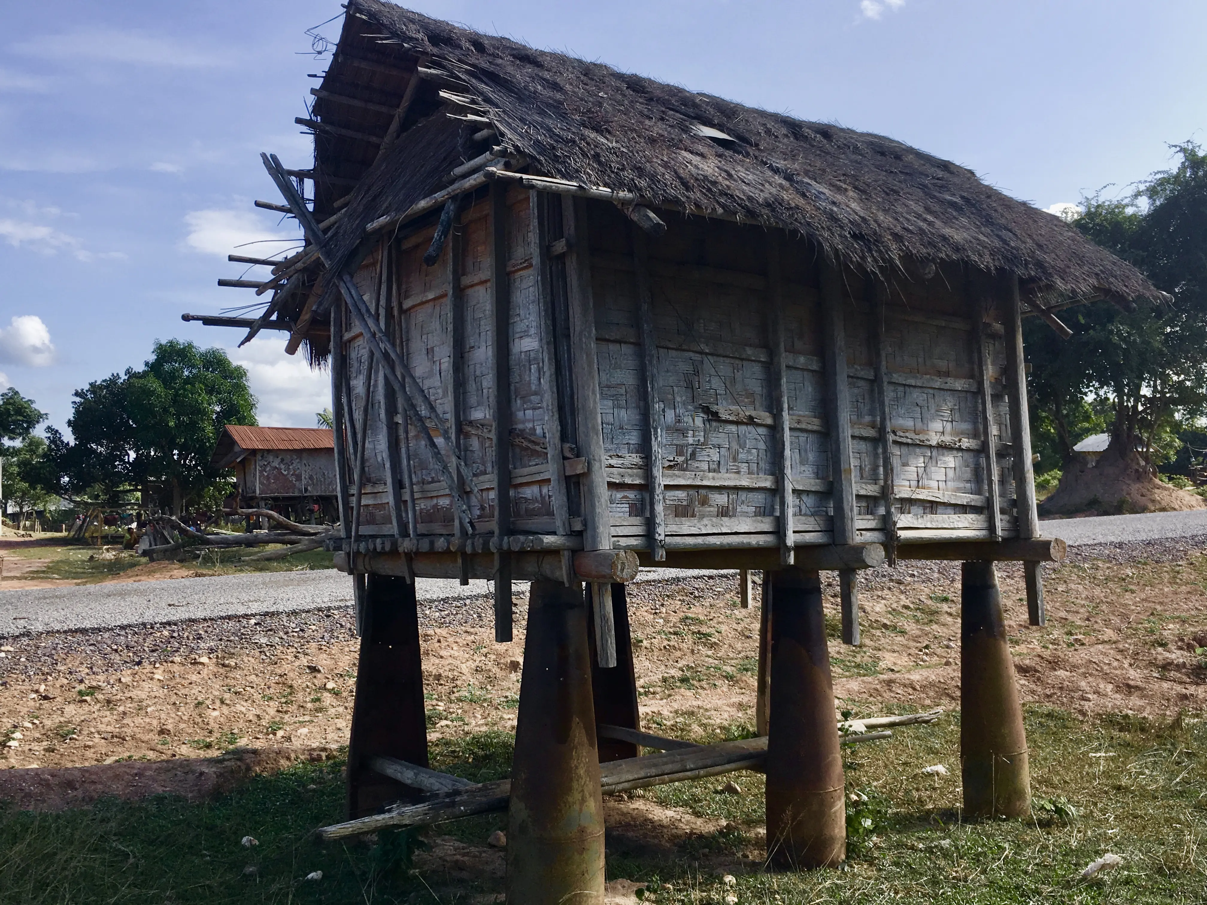 A wooden building atop stilts made of cluster bomb casings.