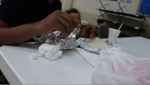 A hand grabs at aluminum foil and food