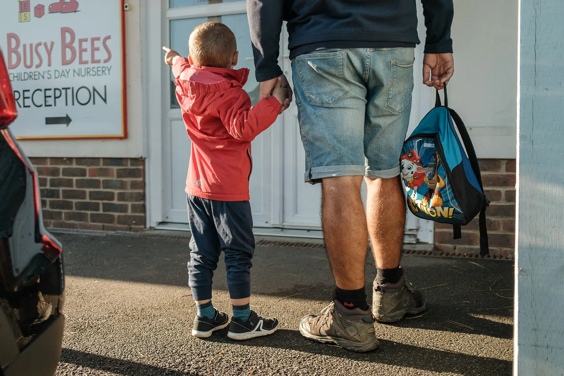 Young boy points at nursery sign 