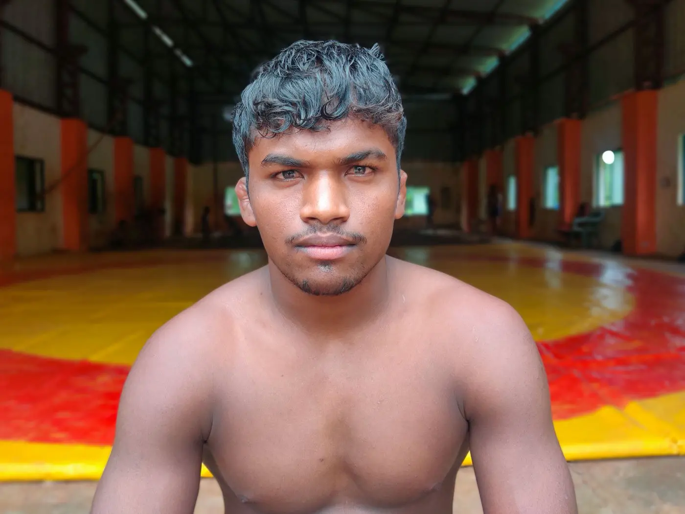 photo of boy sitting in front of wrestling space