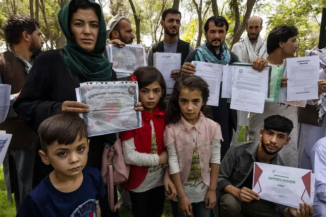 A group of people pose with documents 