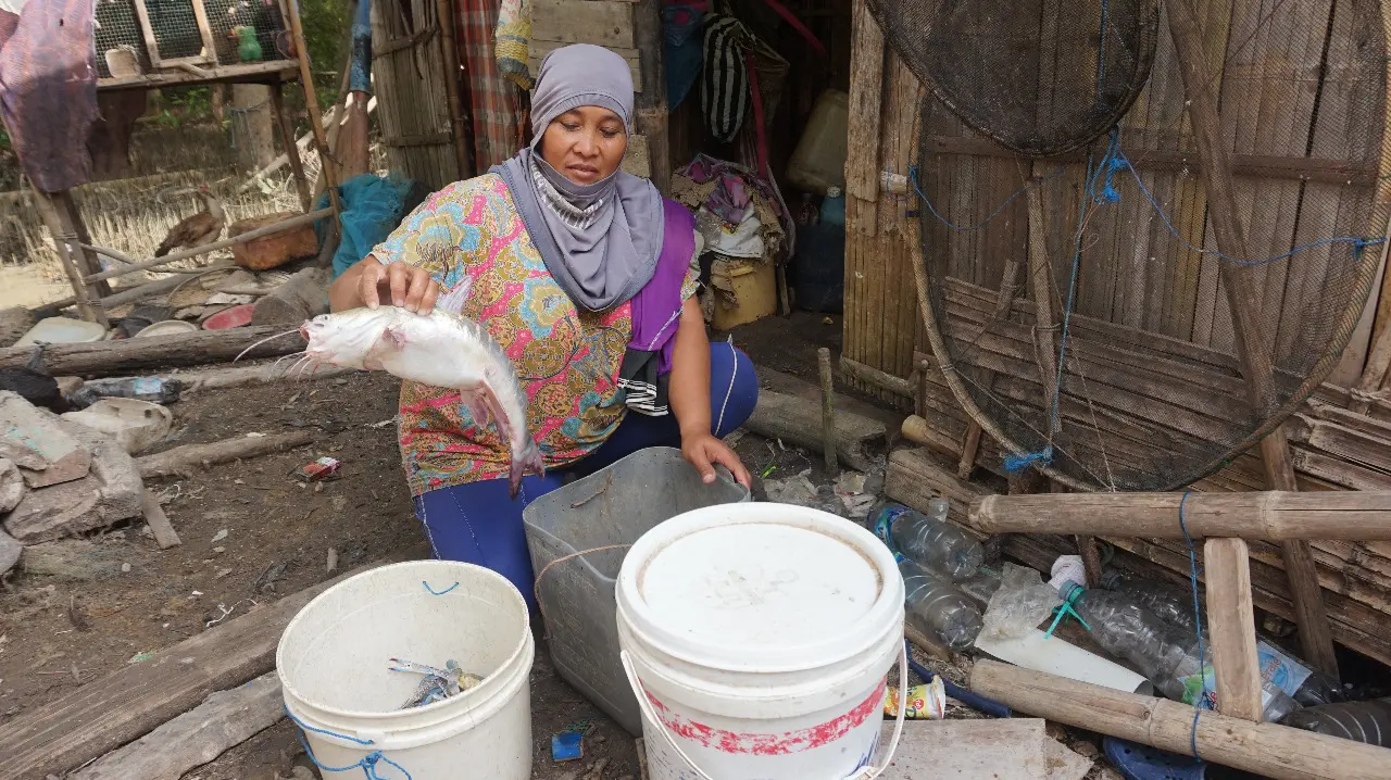 A woman holds a fish 