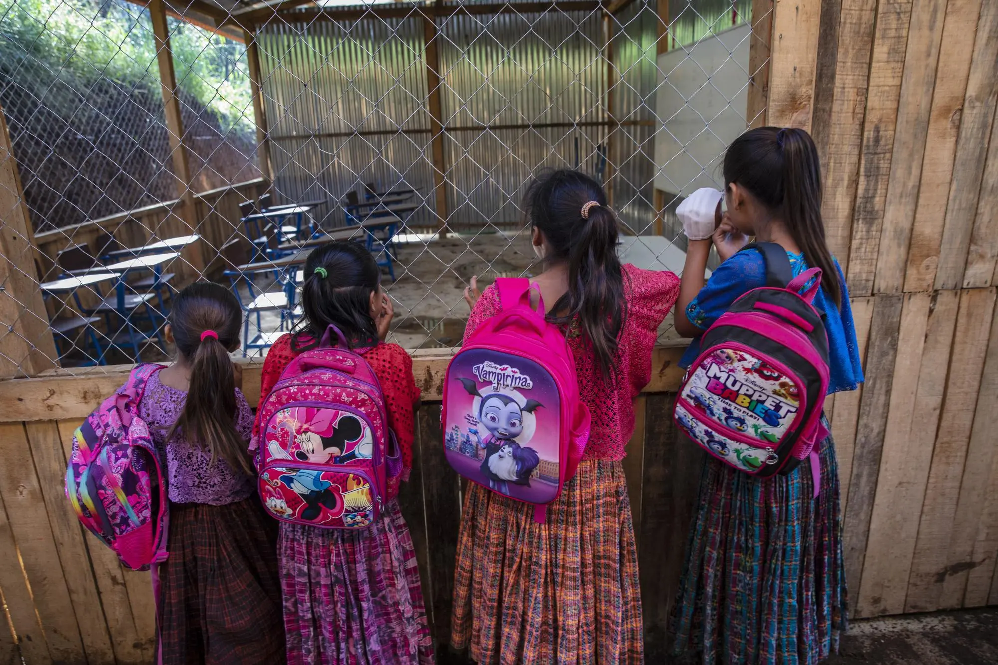 Children look into their flooded classroom