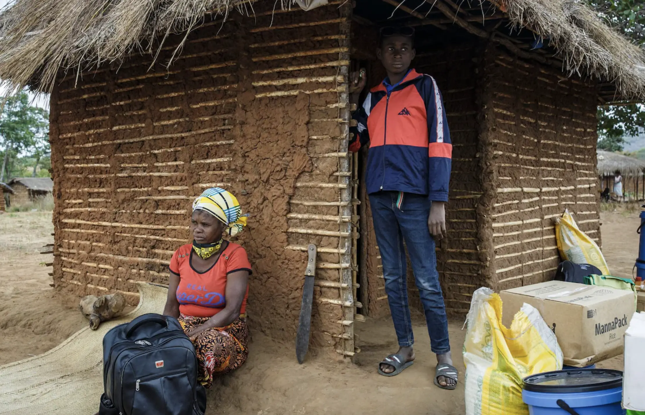 Young boy and his mother sit outside house together