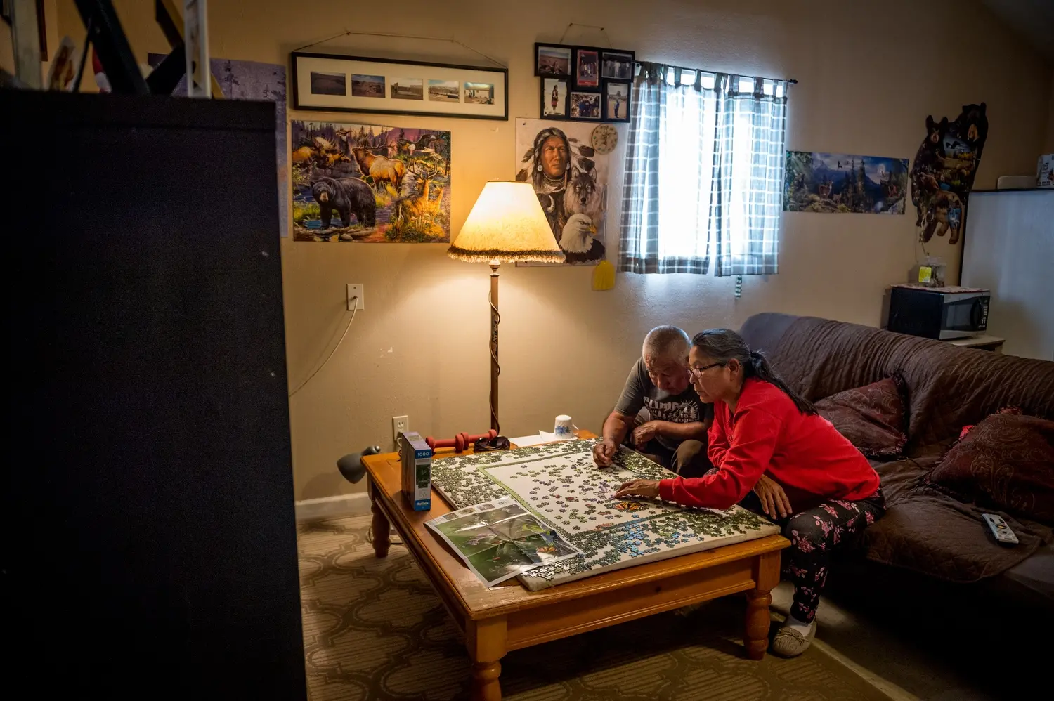 Leona Talker is pictured putting a puzzle together with her father, Tommy Talker. Image by Mary F. Calvert. United States, 2020.