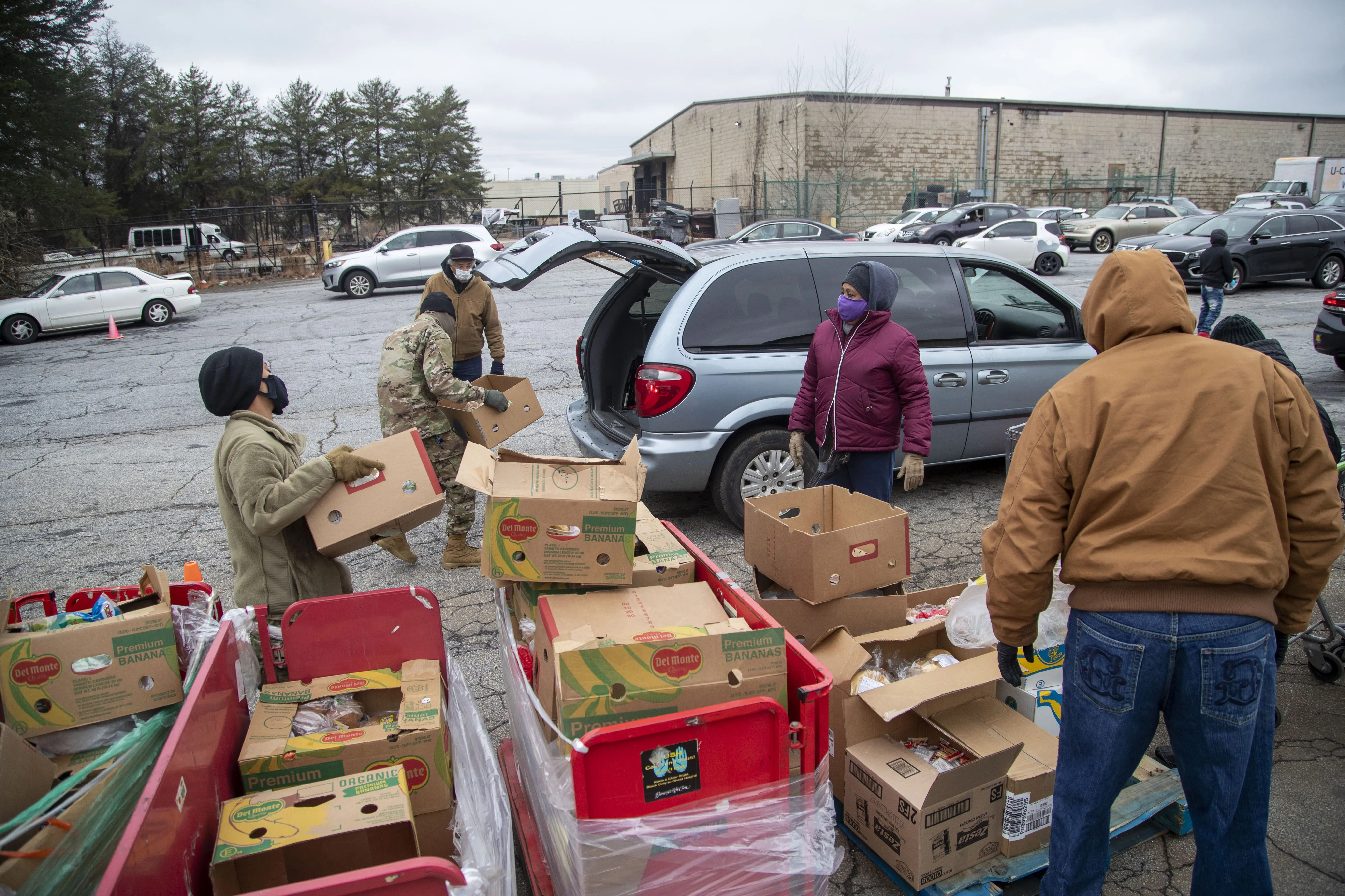 People load boxes into a minivan.
