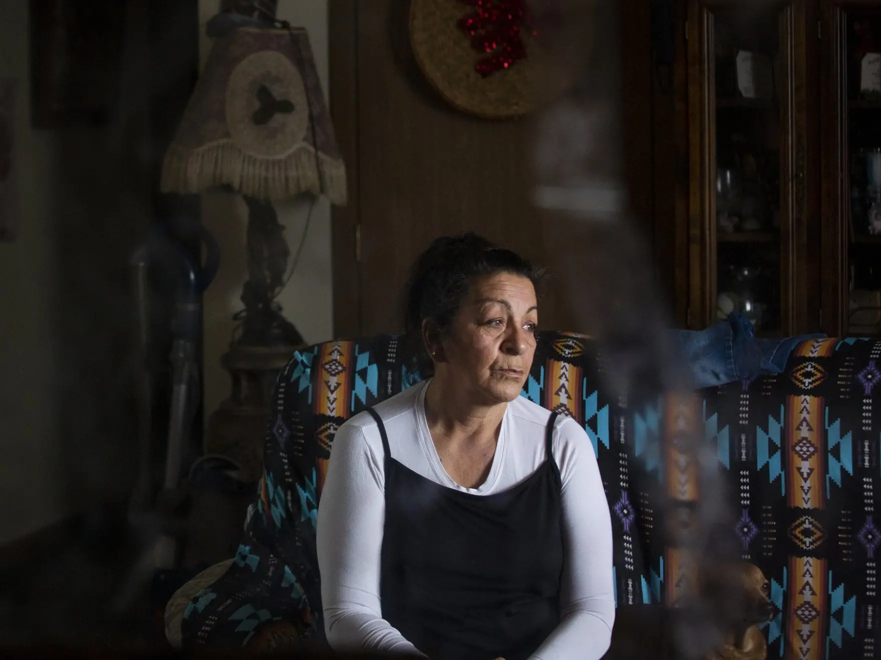 Woman sits on couch in her home