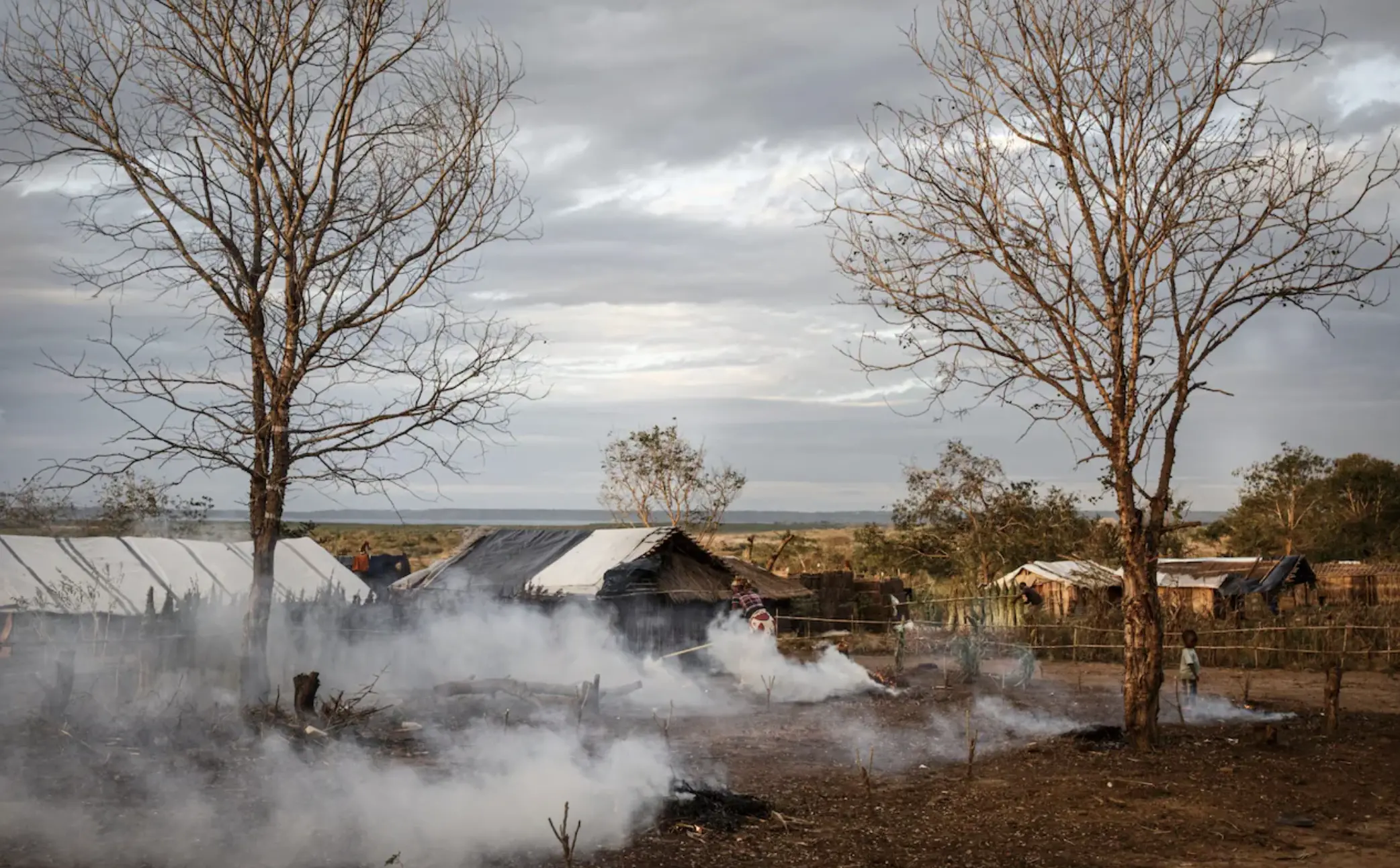 A woman burns rubbish in her resettlement