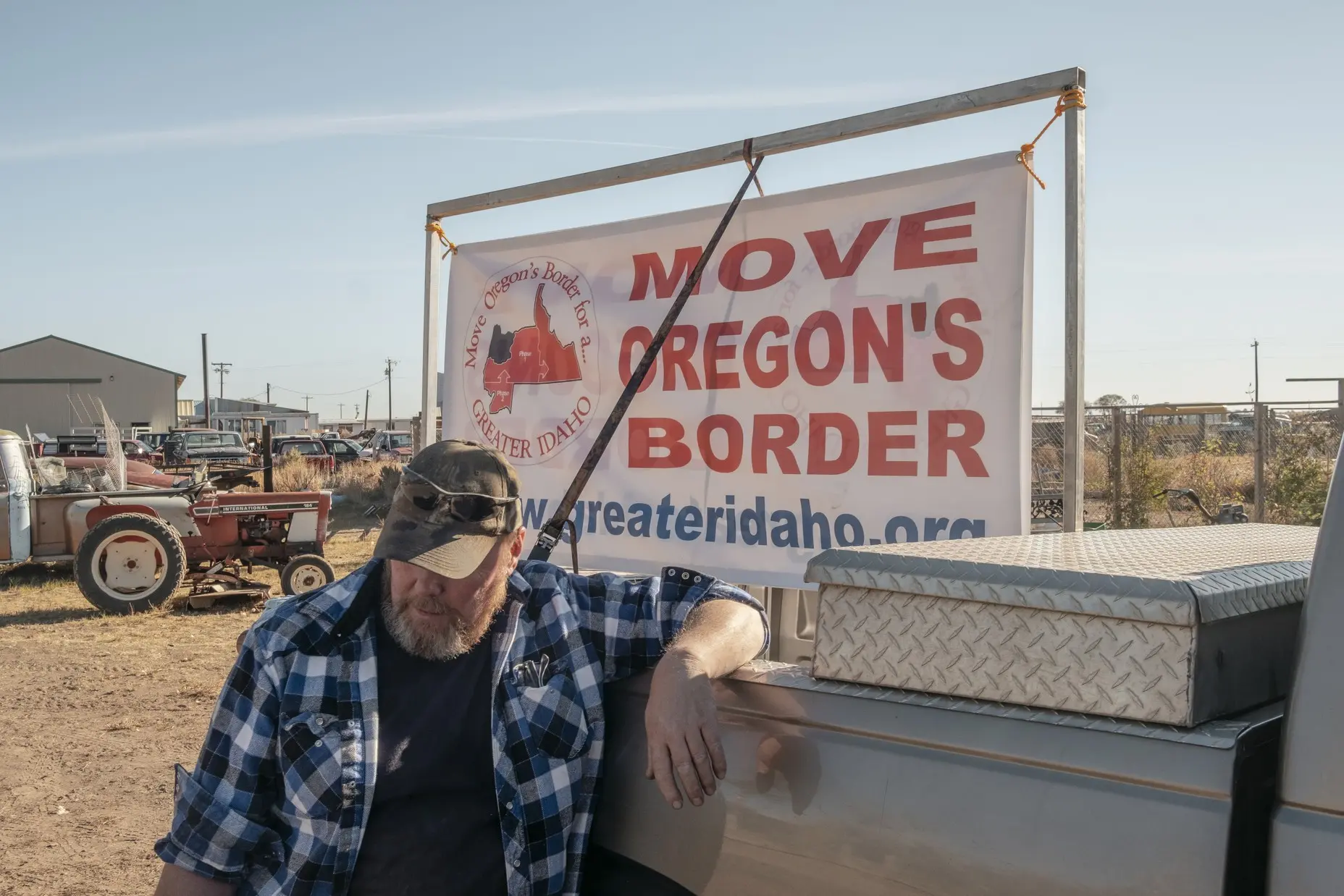 Man prepares a Move Oregon's Border sign outside a business 