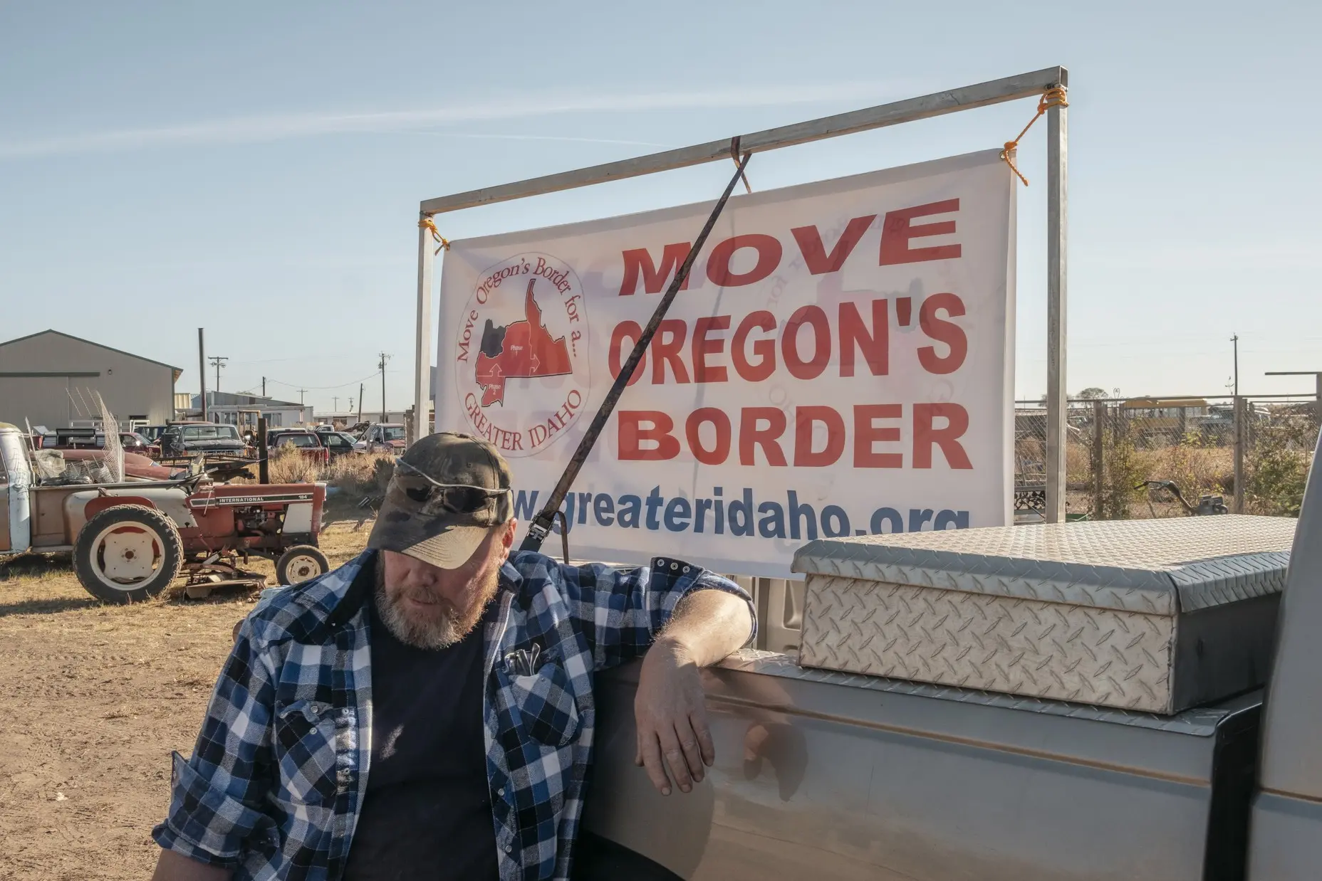 Man prepares a Move Oregon's Border sign outside a business