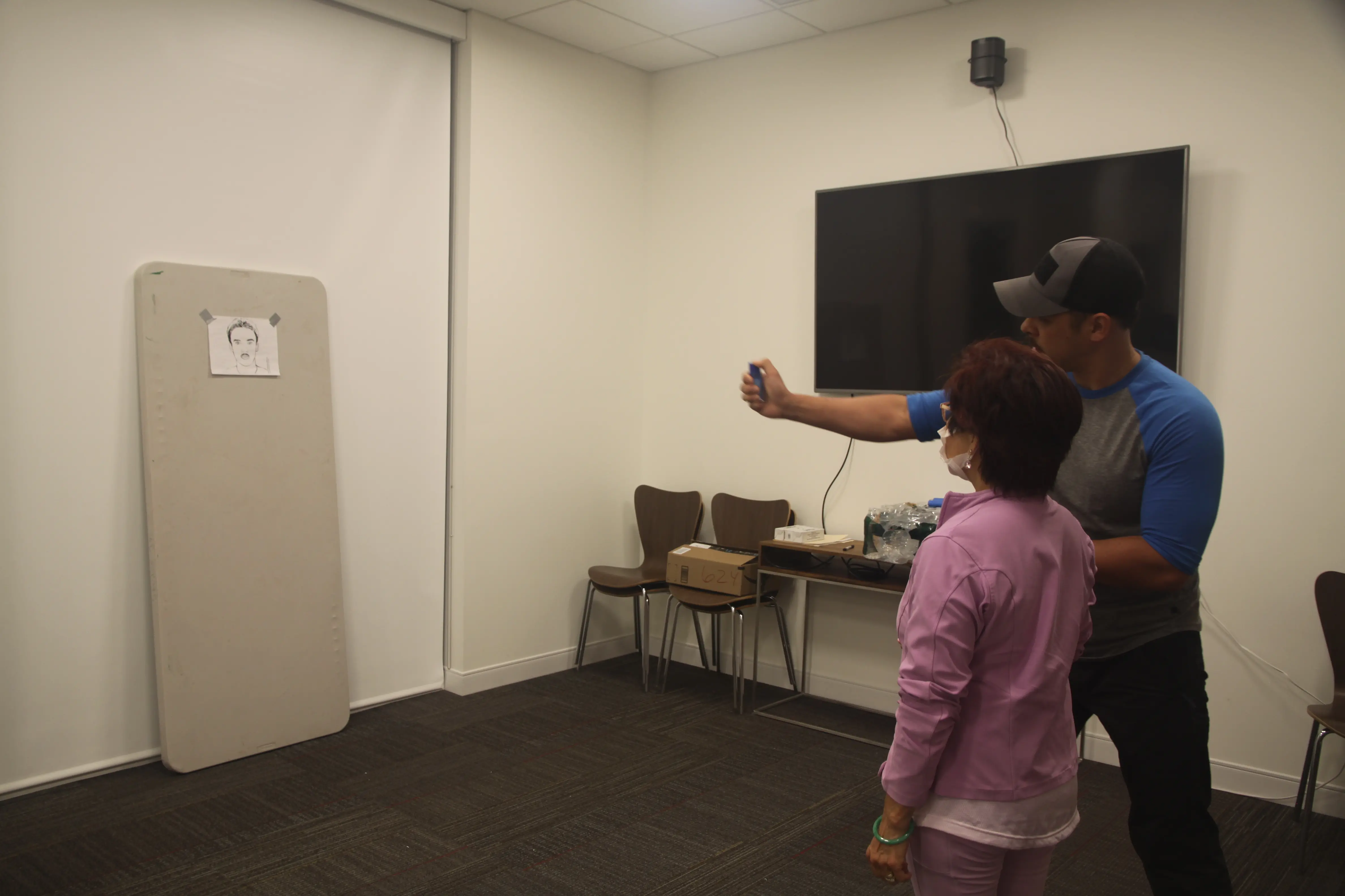 Photo of man showing woman how to use pepper spray