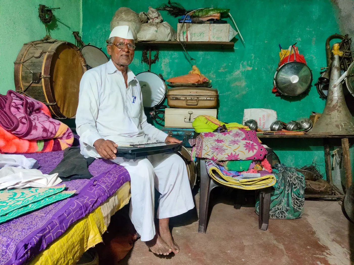 Man sits on bed with musical instrument 