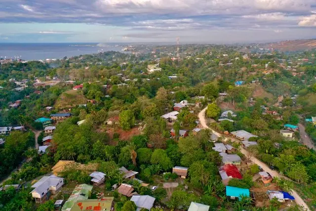 Aerial view of a residential area with lots of vegetation and close to the coastline.