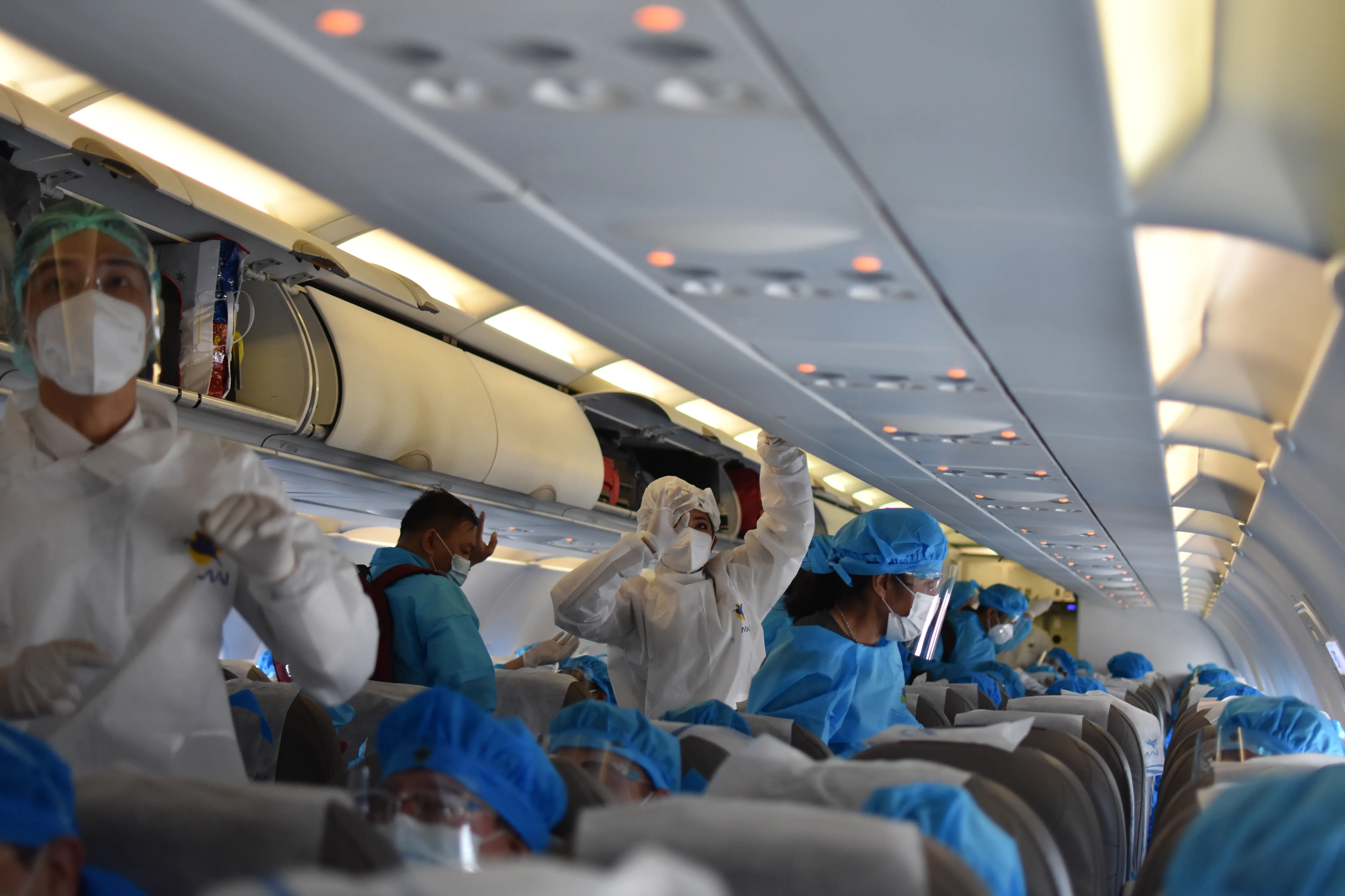 Passengers in PPE board an airplane.