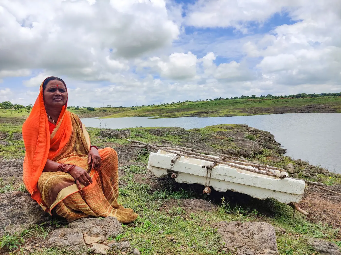 Woman sits next to old raft