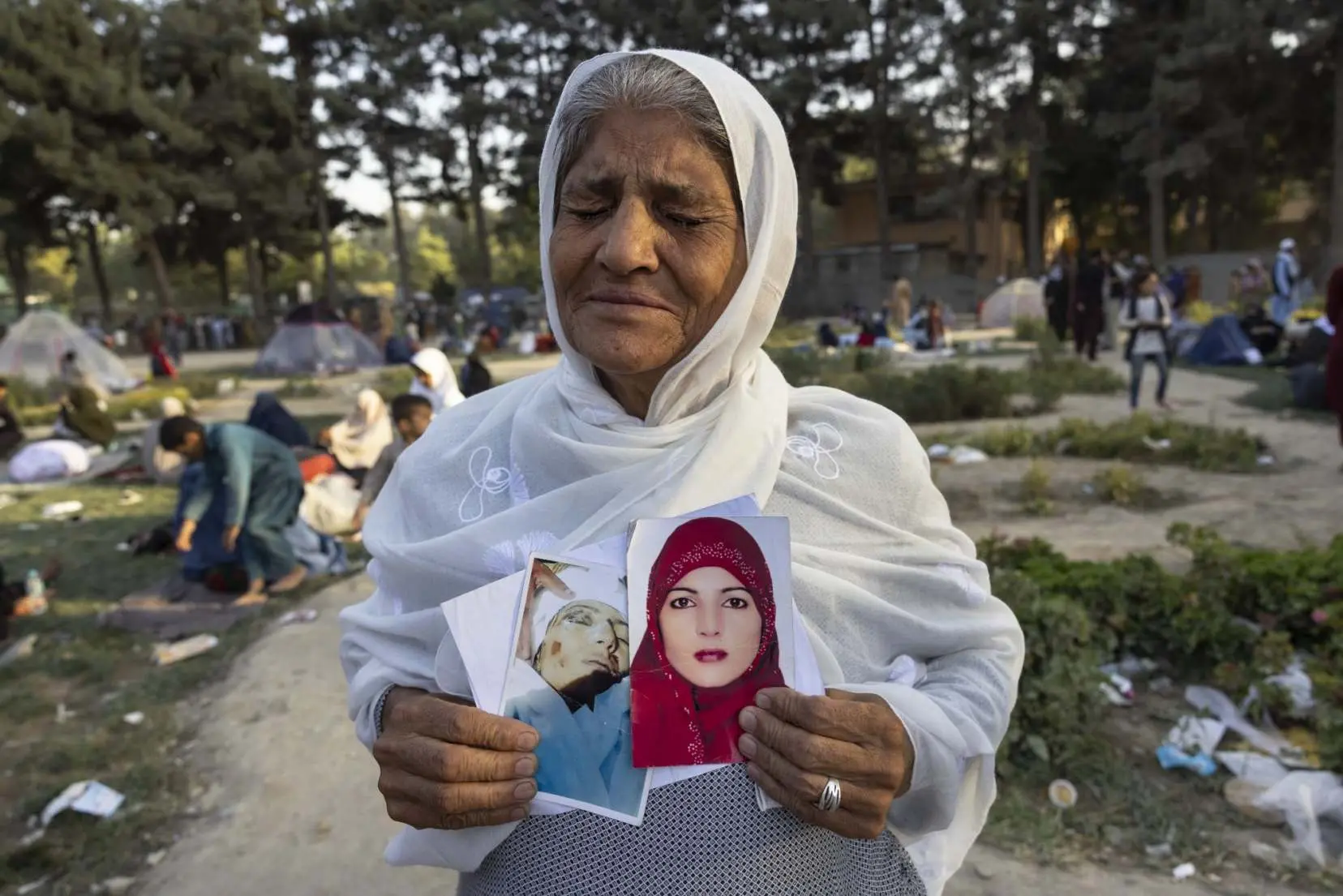 A woman holds photo of her children