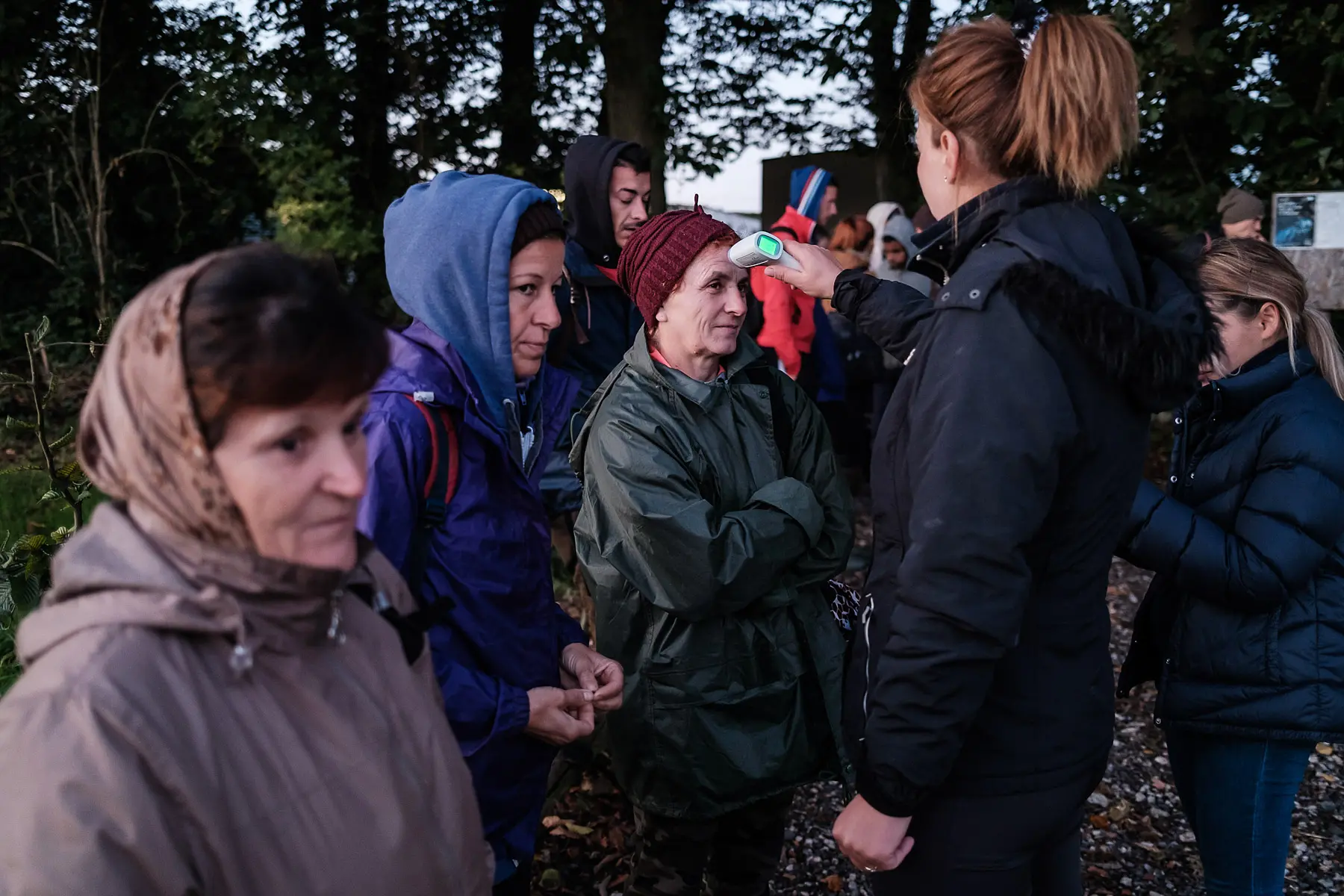 Alexandra Scarlat, farm supervisor, takes the temperature of seasonal workers.