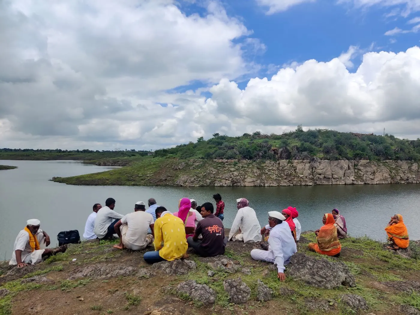 Villagers sit on the bank of the river