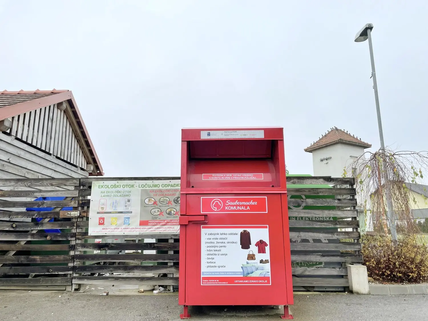 A damaged textile waste container on the street
