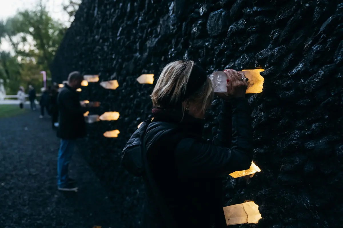 A woman holds a crystal on the crystal wailing wall