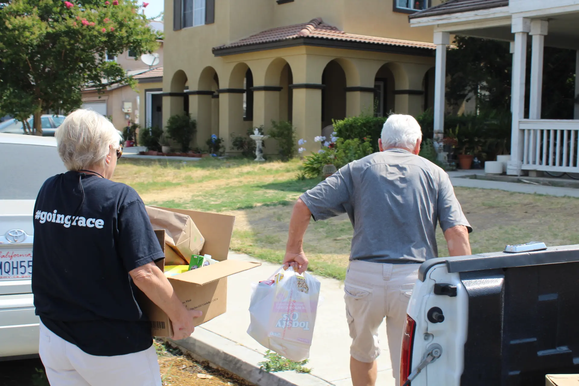 A woman and her husband carry in groceries 