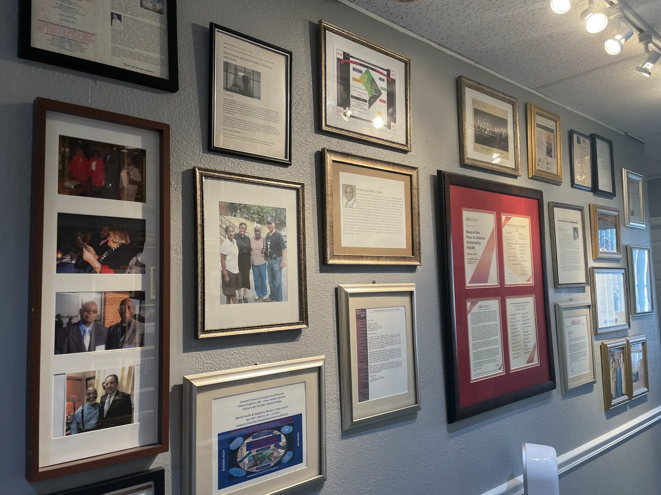 hallway wall covered with photos, maps, and other items