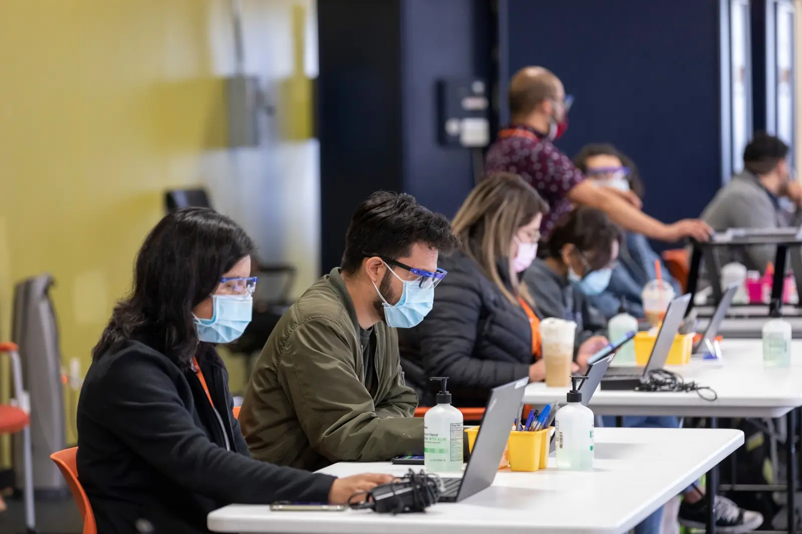 Volunteers sit masked a check-in table at a vaccination event in Chicago.