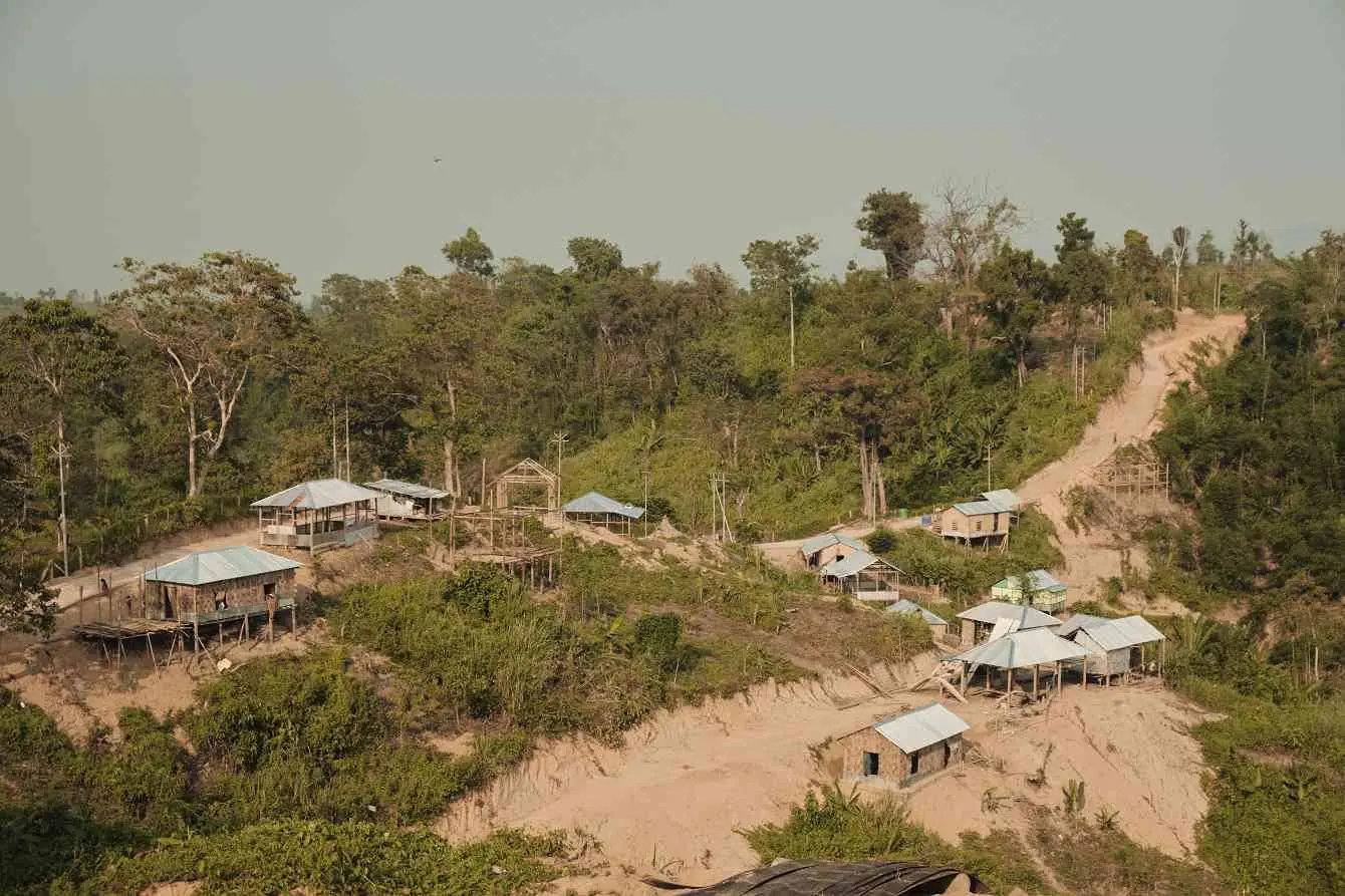 Stilted homes on a sandy and desiccated hill.