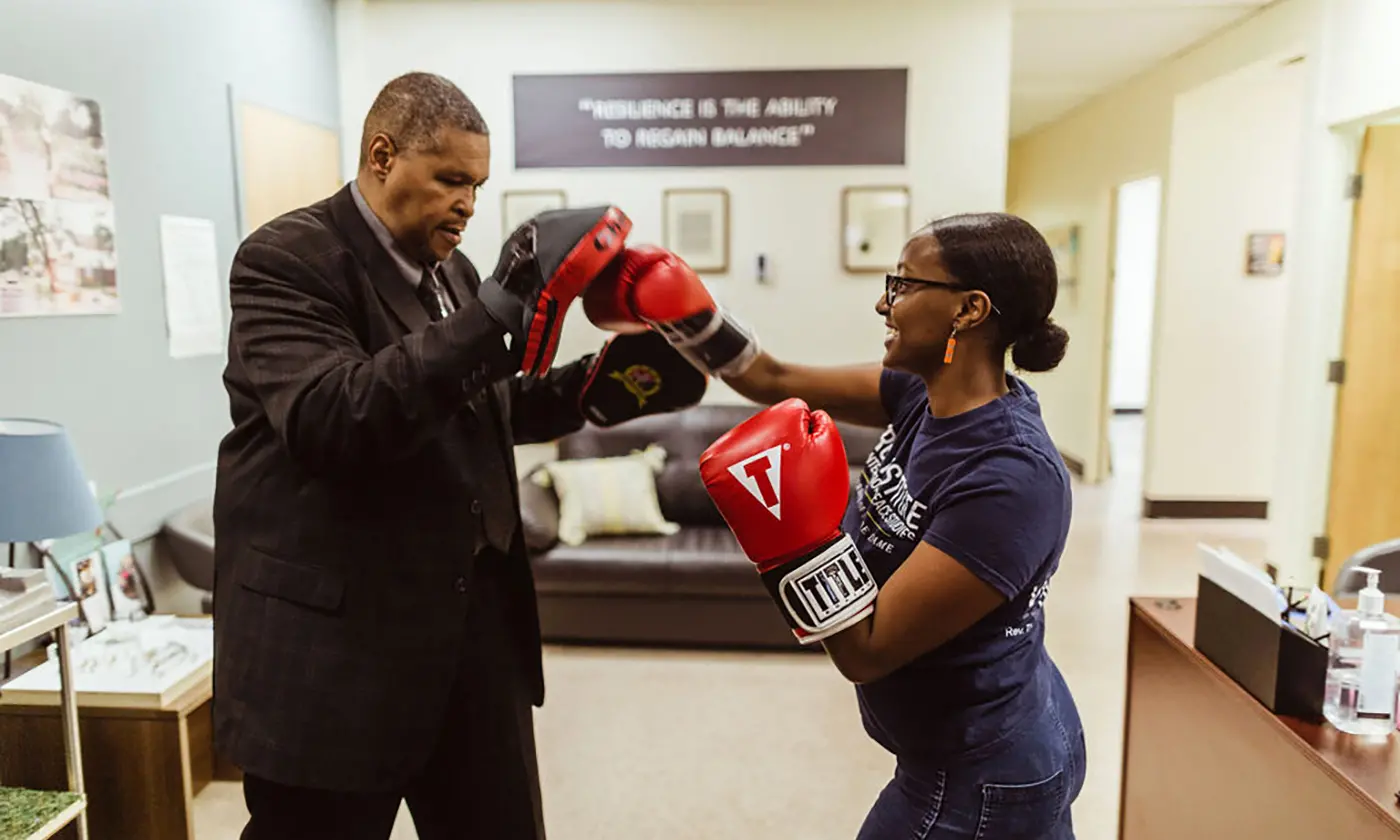 Gregory Banks—a torture survivor and CTJC Learning Fellow—boxes with a former intern, Helina Haile. Banks and Haile worked on launching a community healing boxing program at the Chicago Torture Justice Center.