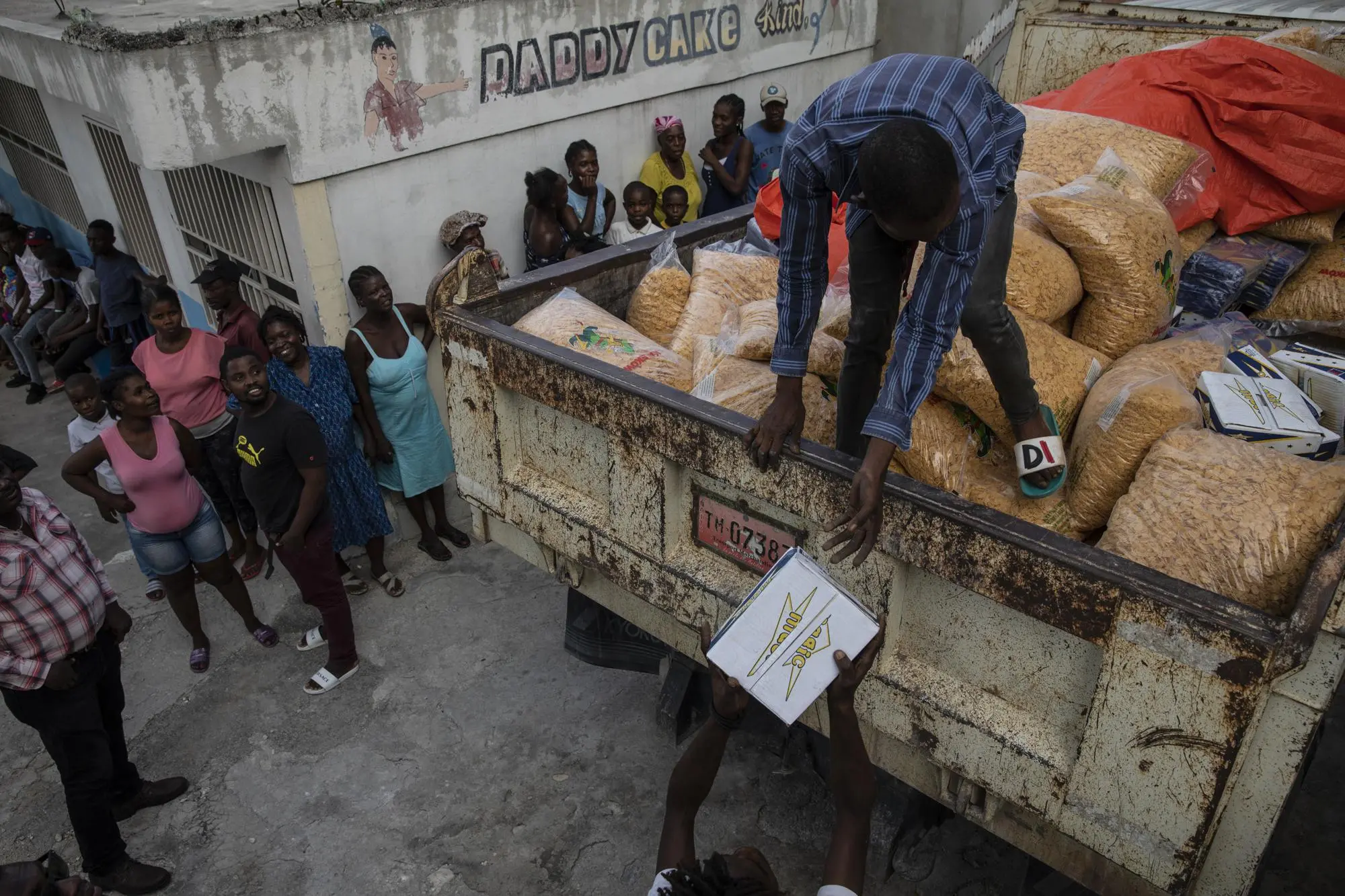 a work hands out corn flakes to neighborhood residents
