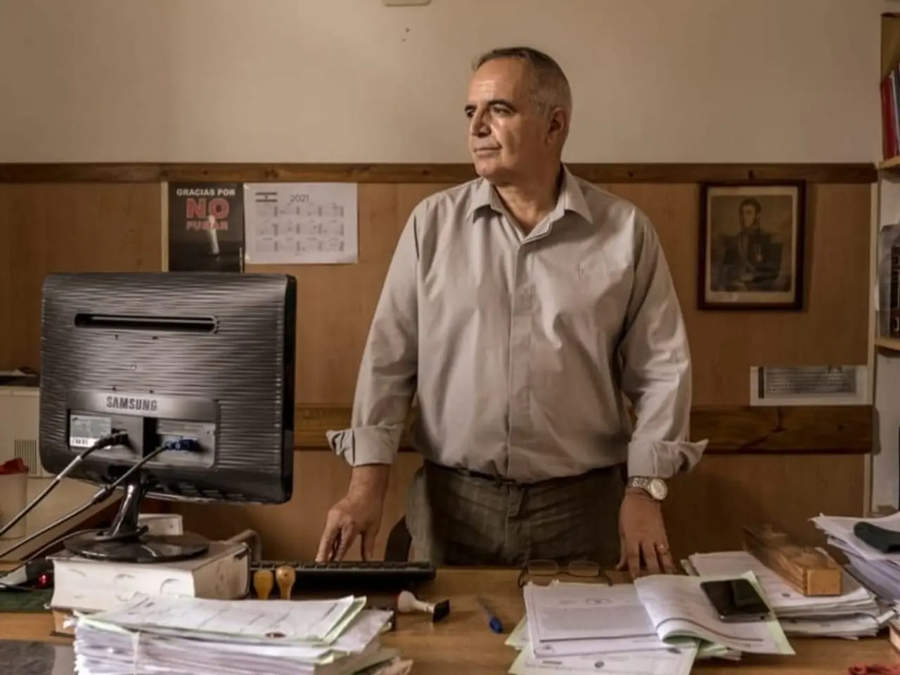 man stands in front of his desk